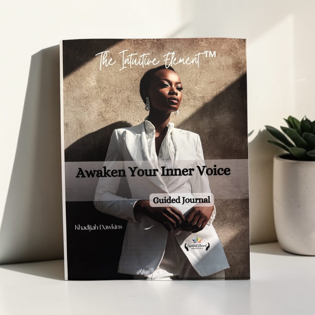 Book titled 'Awaken Your Inner Voice' with a woman in white blazer on cover, placed on a white surface with a plant nearby.