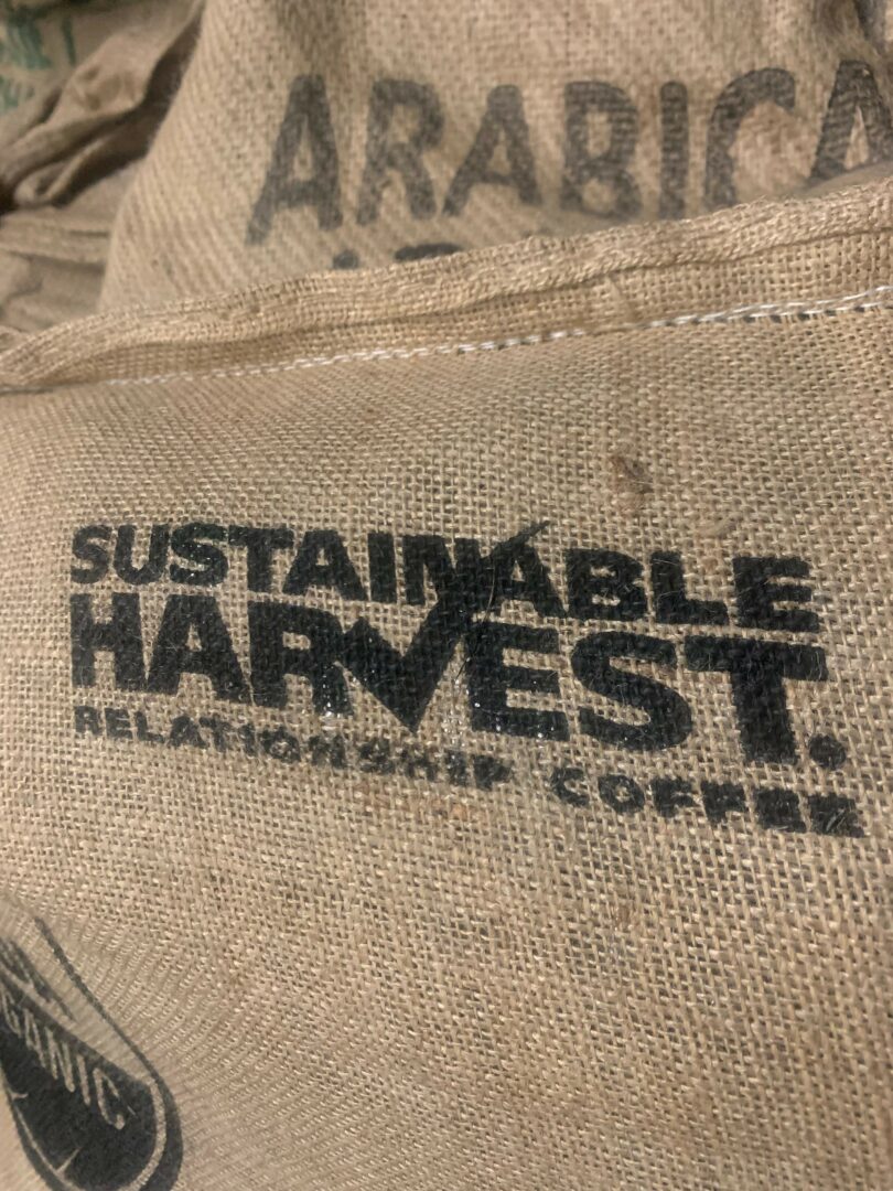 Close-up of a fabric bag with black printed text and a logo, showing the words 